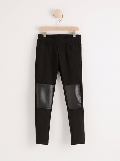 Svarta jeggings med knälappar i konstläder